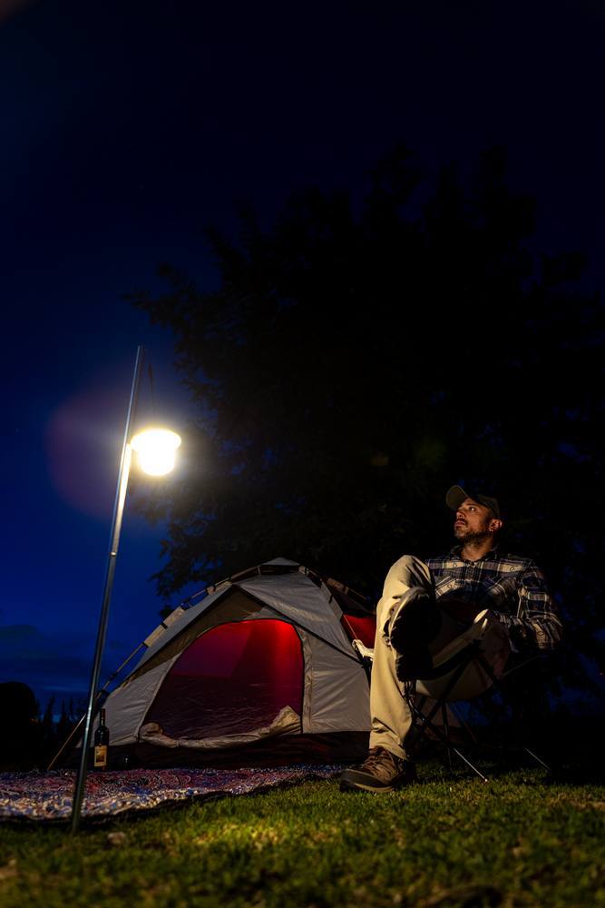 man looking at star sitting at camp base with his tent in the Vesuvius National Park