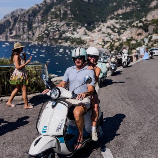 couple in vespa in front of Positano