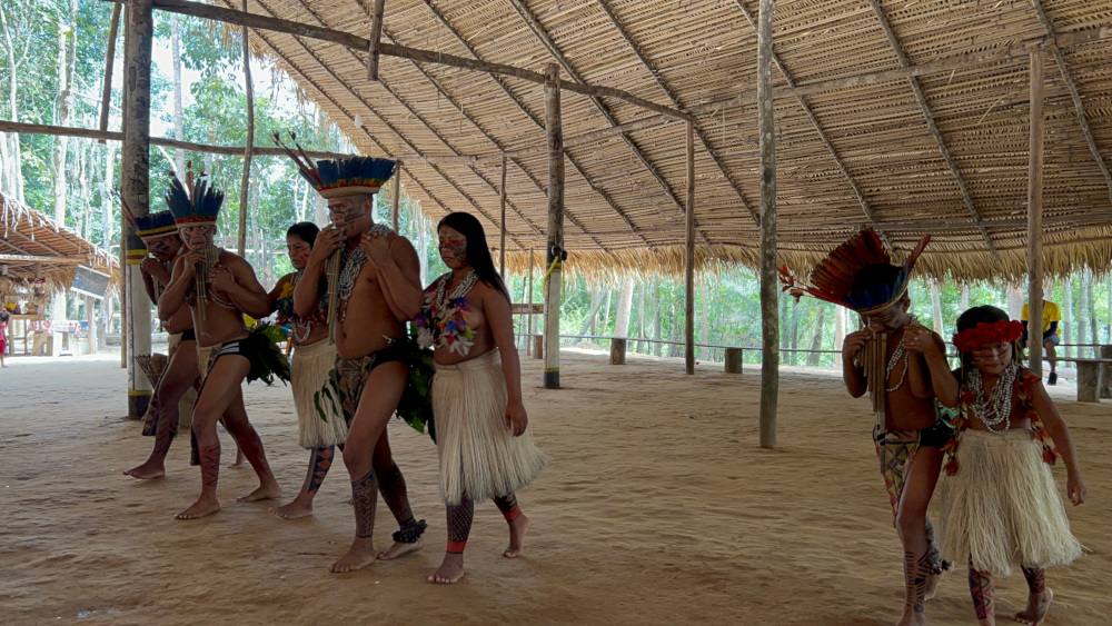 indigeni brasiliani che suonano e ballano all'interno di un villaggio