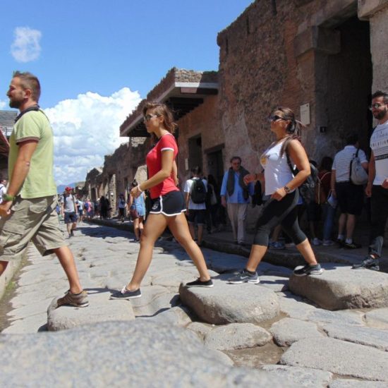 Group of tourists walinking inside Pompeii ruins