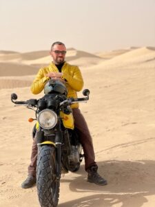 Uomo in moto circondato dal deserto