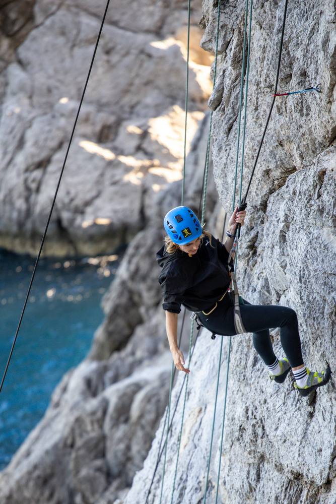 donna si arrampica sulle falesie vertiginose di punta campanella in costiera sorrentina