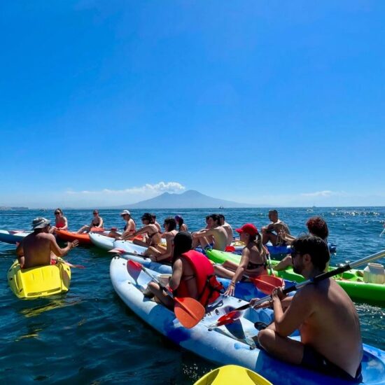 gruppo di giovani in kayak che ascoltano la guida turistica nel golfo di napoli