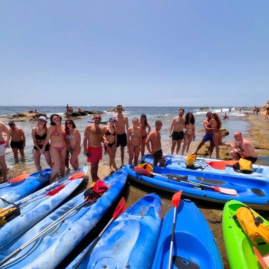 gruppo di giovani che sostano con il kayak sulle scogliere in tufo di Posillipo