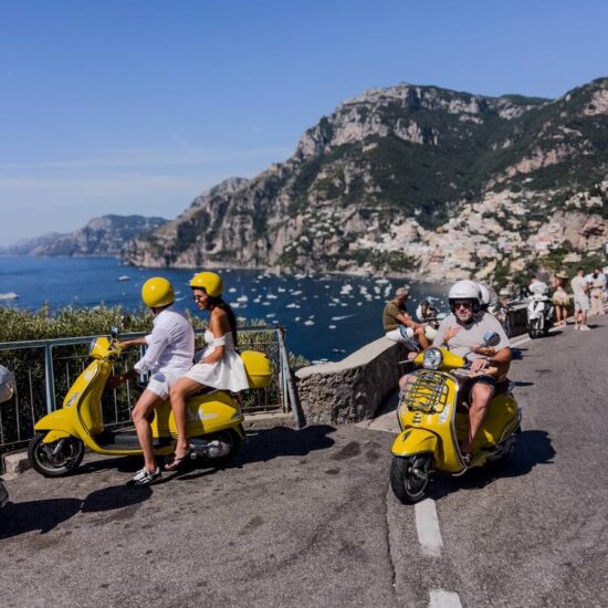 turisti vanno in giro in vespa in costiera amalfitana