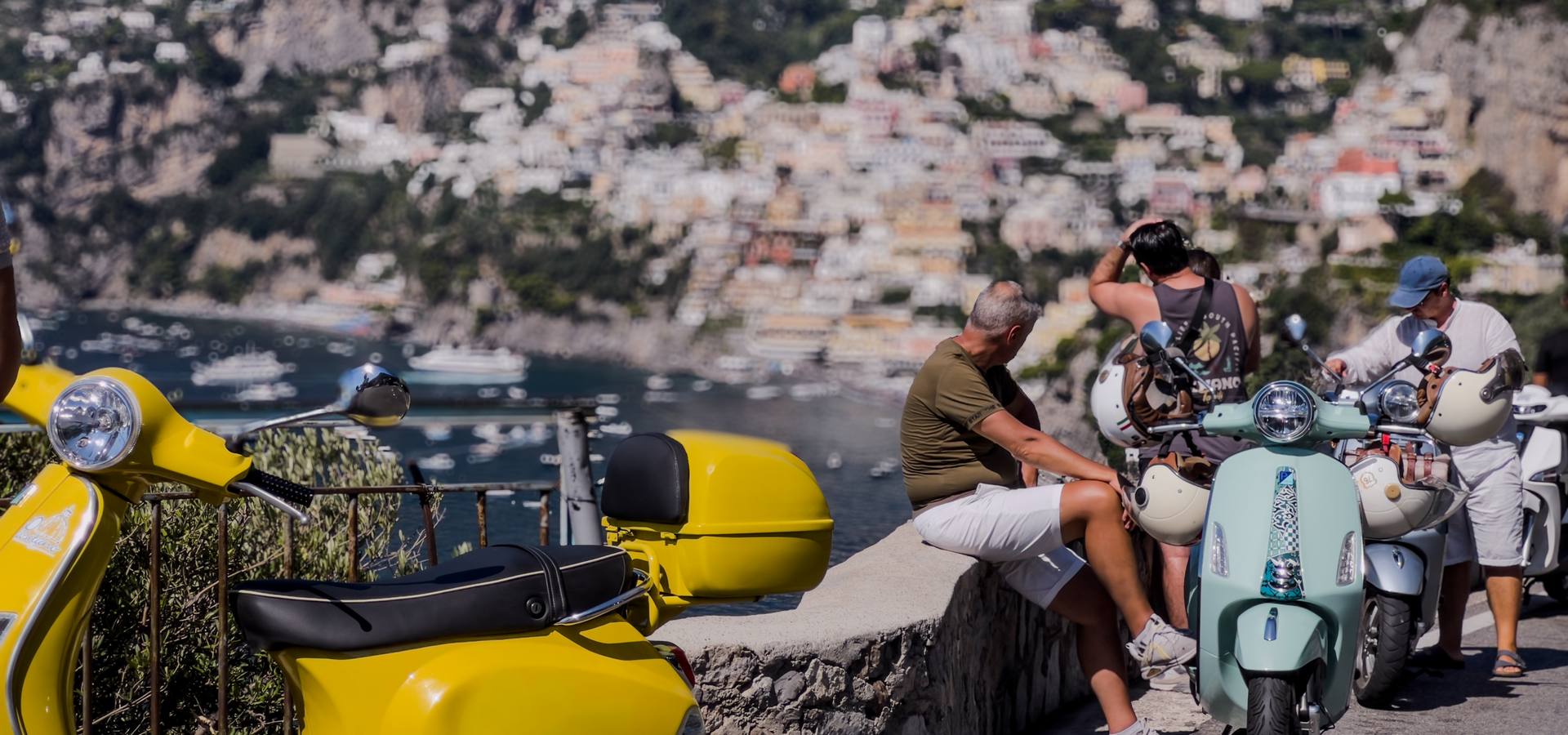 persone fanno una pausa di fronte Positano nel Vespa photo tour in Costiera amalfitana